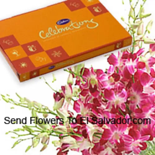 Un hermoso manojo de orquídeas rosadas junto con una hermosa caja de chocolates Cadbury