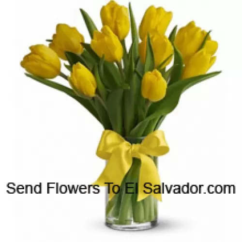 Yellow Tulips With Seasonal Fillers And Leaves In A Glass Vase - Please Note That In Case Of Non-Availability Of Certain Seasonal Flowers The Same Will Be Substituted With Other Flowers Of Same Value