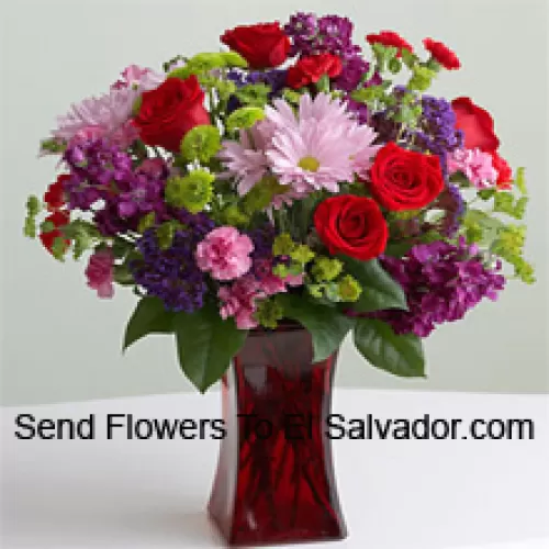 Red Roses, Pink Carnations And Other Assorted Seasonal Flowers In A Glass Vase