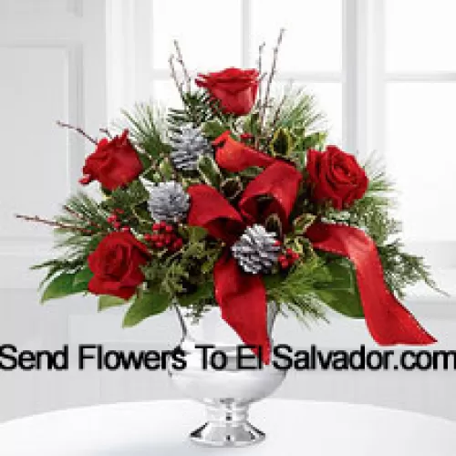 Altamente elegante y rebosante de tus deseos más alegres, este ramo creará el regalo navideño perfecto. Las rosas rojas son vibrantes y brillantes, dispuestas con acebo variado, verdes navideños surtidos, piñas plateadas y ramas, todo perfectamente acentuado con un falso cardenal y cinta roja de diseñador. Presentado en un jarrón de pedestal plateado, este ramo agregará alegría y festividad a su temporada navideña con cada hermosa flor. (Tenga en cuenta que nos reservamos el derecho de sustituir cualquier producto por un producto adecuado de igual valor en caso de no disponibilidad de cierto producto)